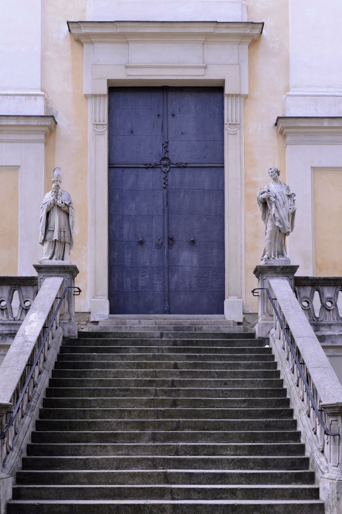 Eine Metallt&uuml;re mit Stiegenaufgang. Schlagworte: Abgang, Aufgang, Geb&auml;ude, Gel&auml;nder, Stadtlandschaft, Statuen, Stufen, Tor, Treppe, T&uuml;r