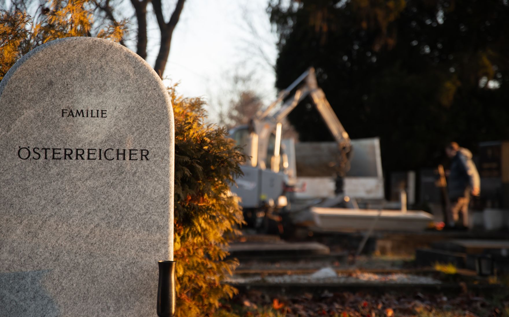 Zentralfriedhof von Wien Schlagw&ouml;rter: Zentralfriedhof, Bagger, Kreuz, Grabsteine, Menschen, Laub, Fr&uuml;hling, Winter, Schaufel, Wien, Baum, B&auml;ume, Jacke, Braun, Gr&uuml;n, Dunkelblau, Hellgr&uuml;n, Kerze, Kerzen, Tod, Gr&auml;ber, Stille, Ruhe, Lichter