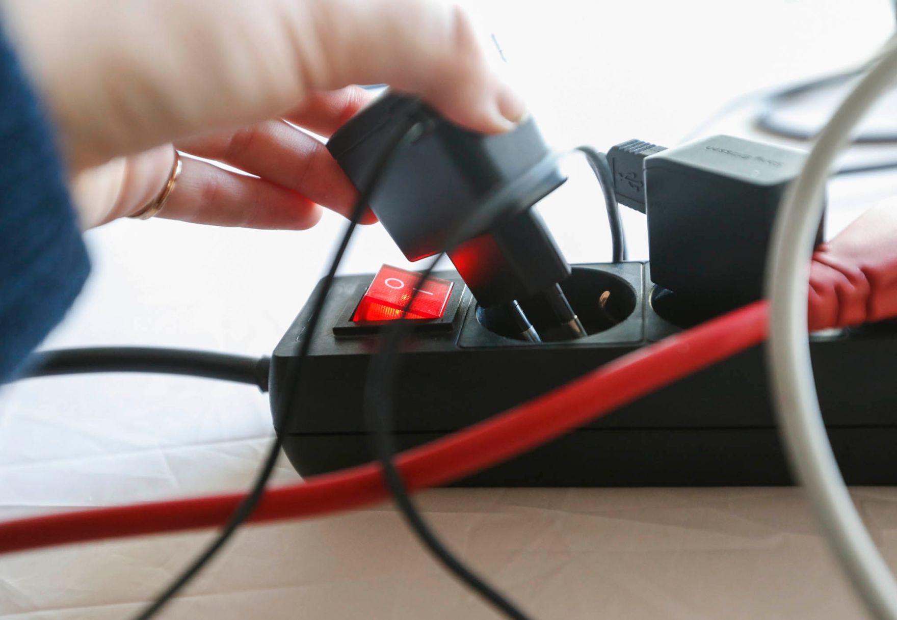 Eine Stromsteckerleiste mit Schalter. Schlagwote: Ger&auml;testecker, Hand, Kabel, Stromverteiler, Technik, Tischsteckdose