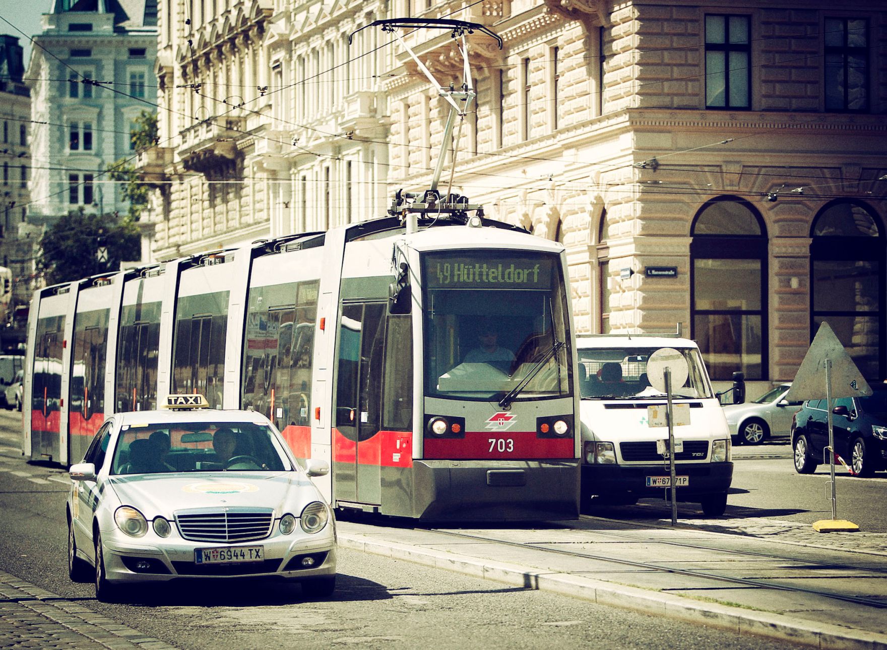 Eine befahrene Stra&szlig;e in Wien. Schlagworte: Autos, Fahrzeuge, Schiene, Stadtlandschaften, Stra&szlig;e, Stra&szlig;enbahn, Taxi, Verkehr, Wiener Linien