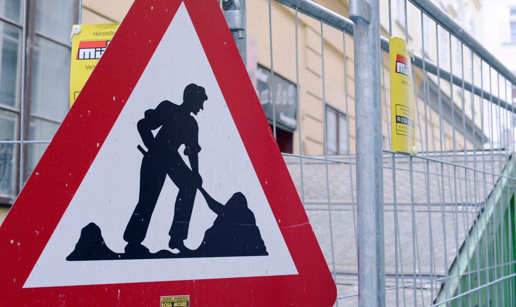 Verkehrsschild "Baustelle". Schlagworte: Beschriftung, Gitter, Verkehr, Verkehrsschild, Verkehrszeichen, Zaun