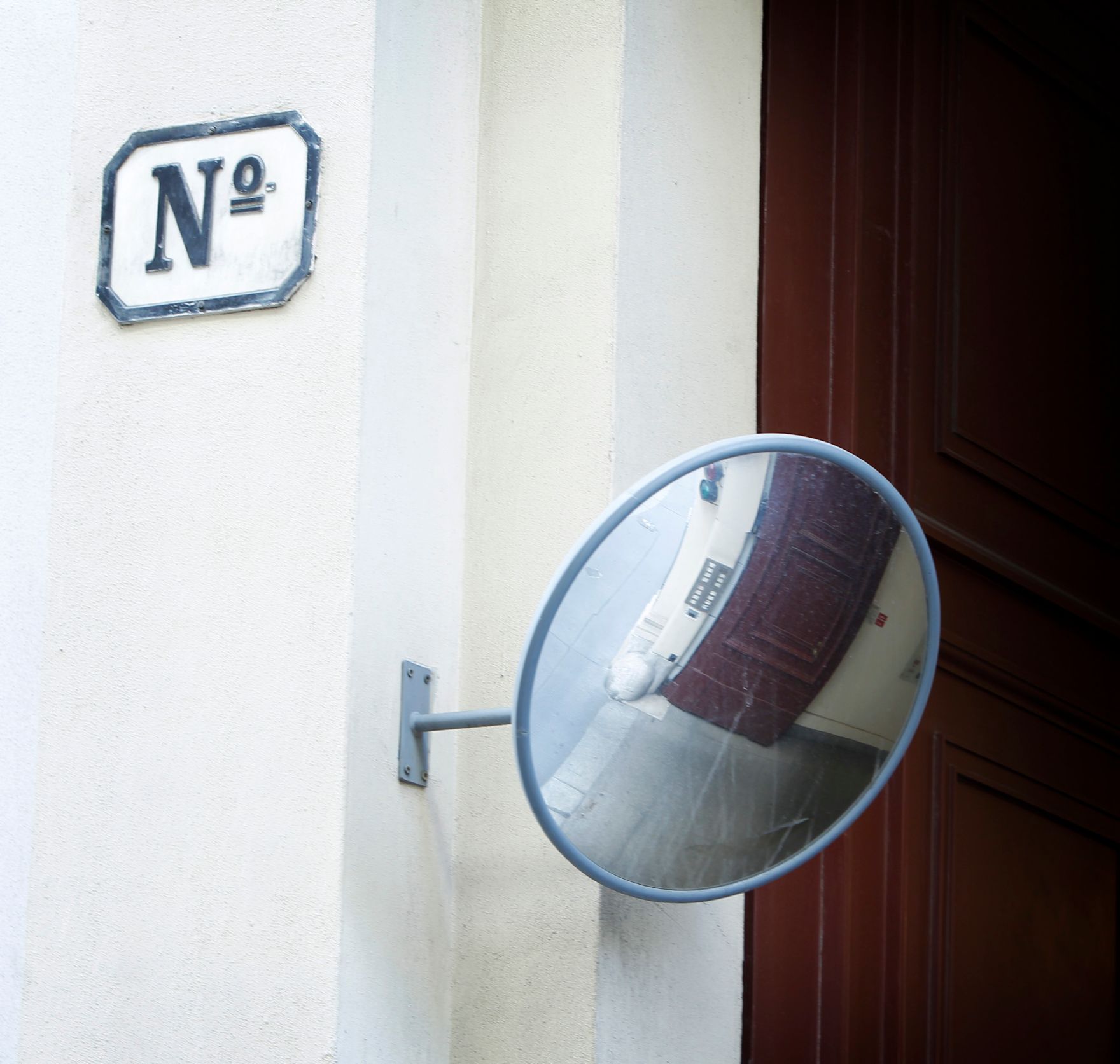 Ein runder Verkehrsspiegel an einem Hauseingang im 1. Bezirk. Schlagworte: Ausfahrt, Beschriftung, Einfahrt, Hausnummer, Tor, T&uuml;r, Verkehr, Verkehrsspiegel