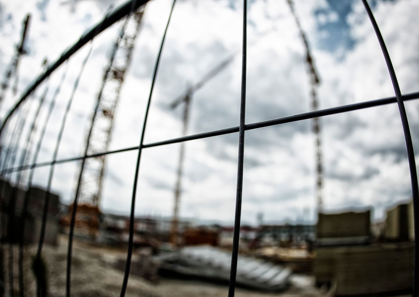 Die Baustelle des &Ouml;BB Hauptbahnhofes in Wien. Schlagworte: Baustelle, Gitter, Kran, Wirtschaft, Wolken, Zaun