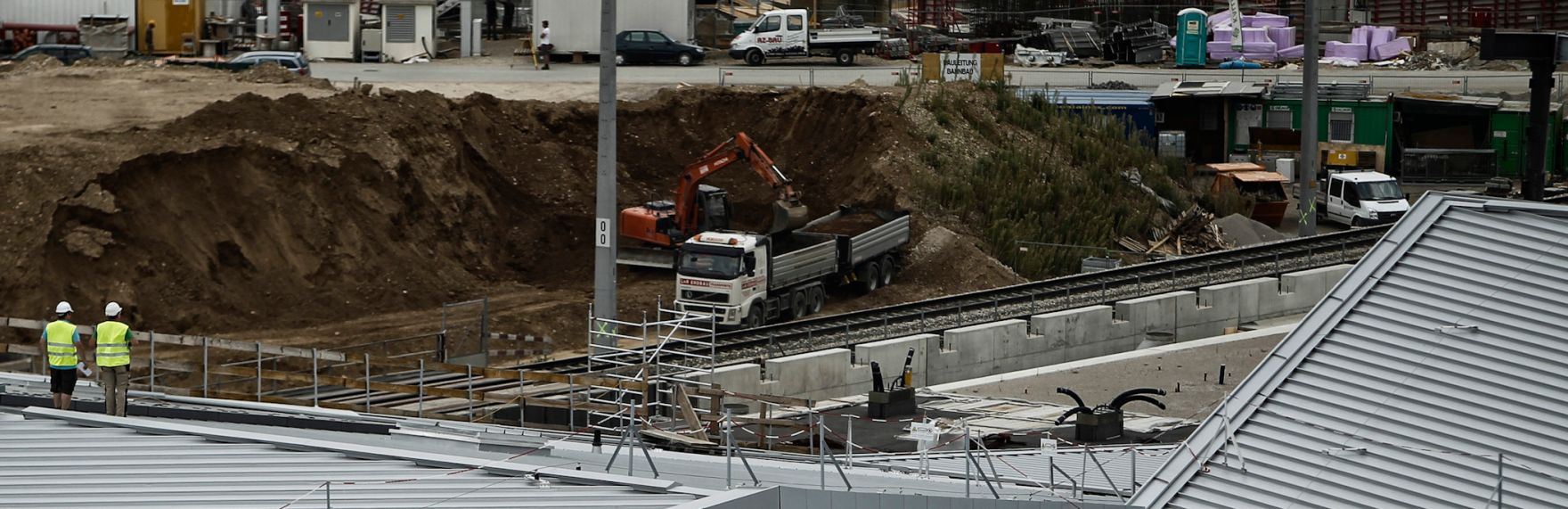 Arbeiter und Fahrzeuge auf der Baustelle des &Ouml;BB Hauptbahnhofes in Wien. Schlagworte: Arbeiter, Auto, Bagger, Baustelle, Fahrzeug, LKW, Menschen, PKW, Wirtschaft