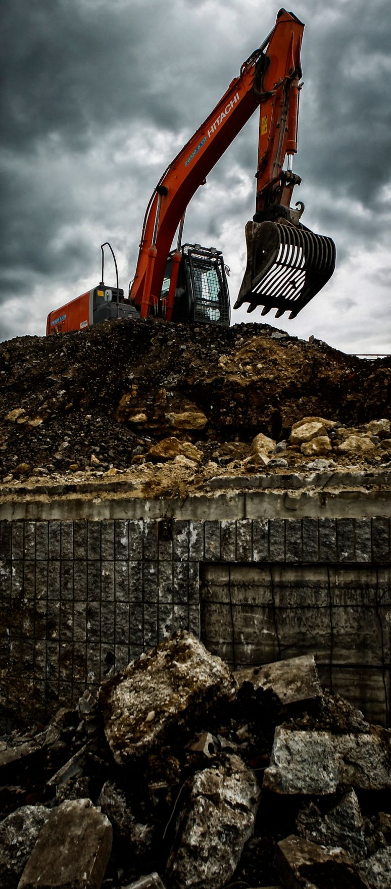 Ein Bagger auf der Baustelle des &Ouml;BB Hauptbahnhofes in Wien. Schlagworte: Abbruch, Bagger, Baustelle, Fahrzeug, Mauer, Wirtschaft, Wolken