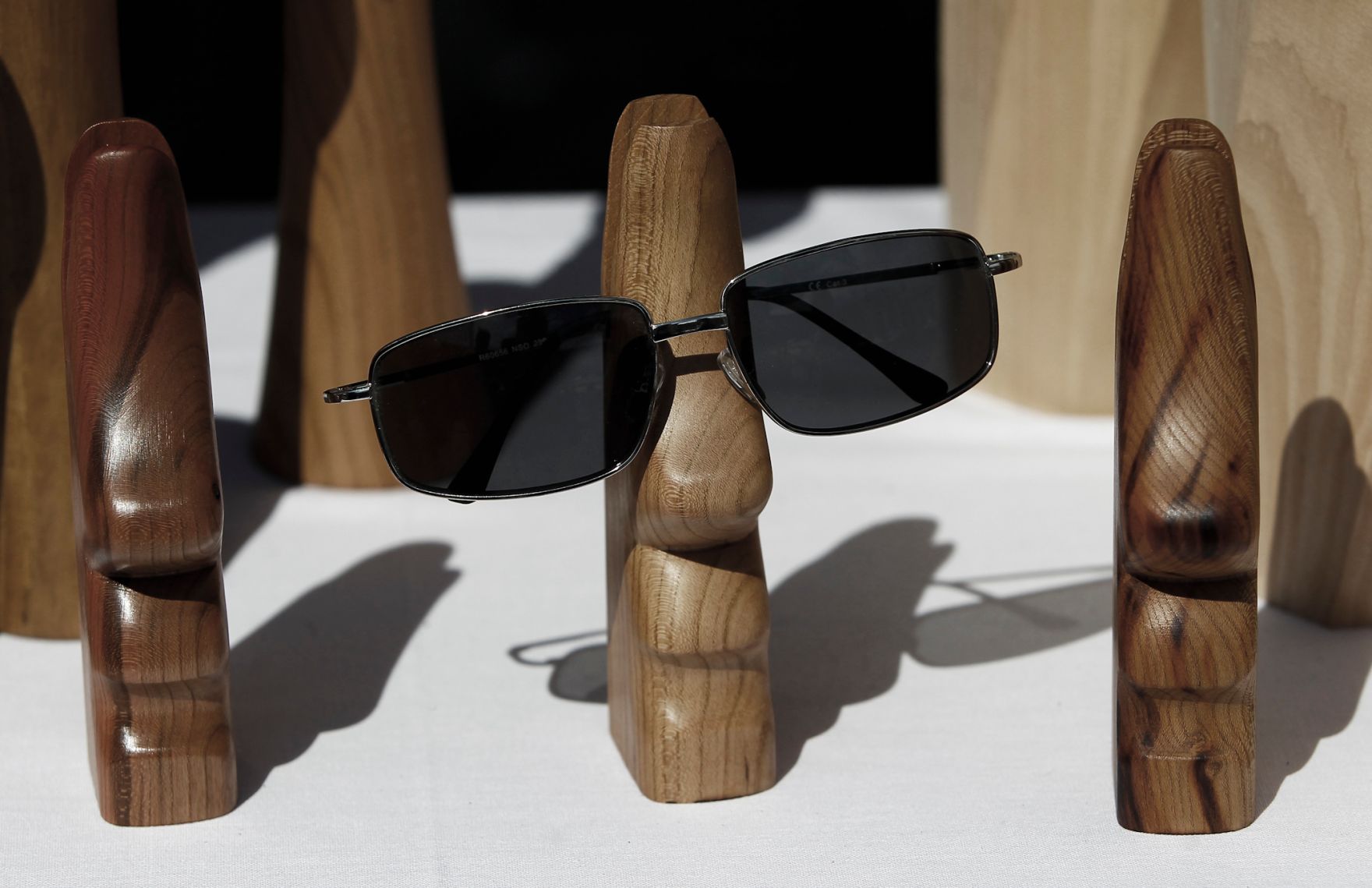 Holzfiguren die als Brillenhalter dienen. Schlagworte: Bauernmarkt, Brille, Markt, Marktst&auml;nde, Schnitzerei, Sonnenbrille, Wirtschaft