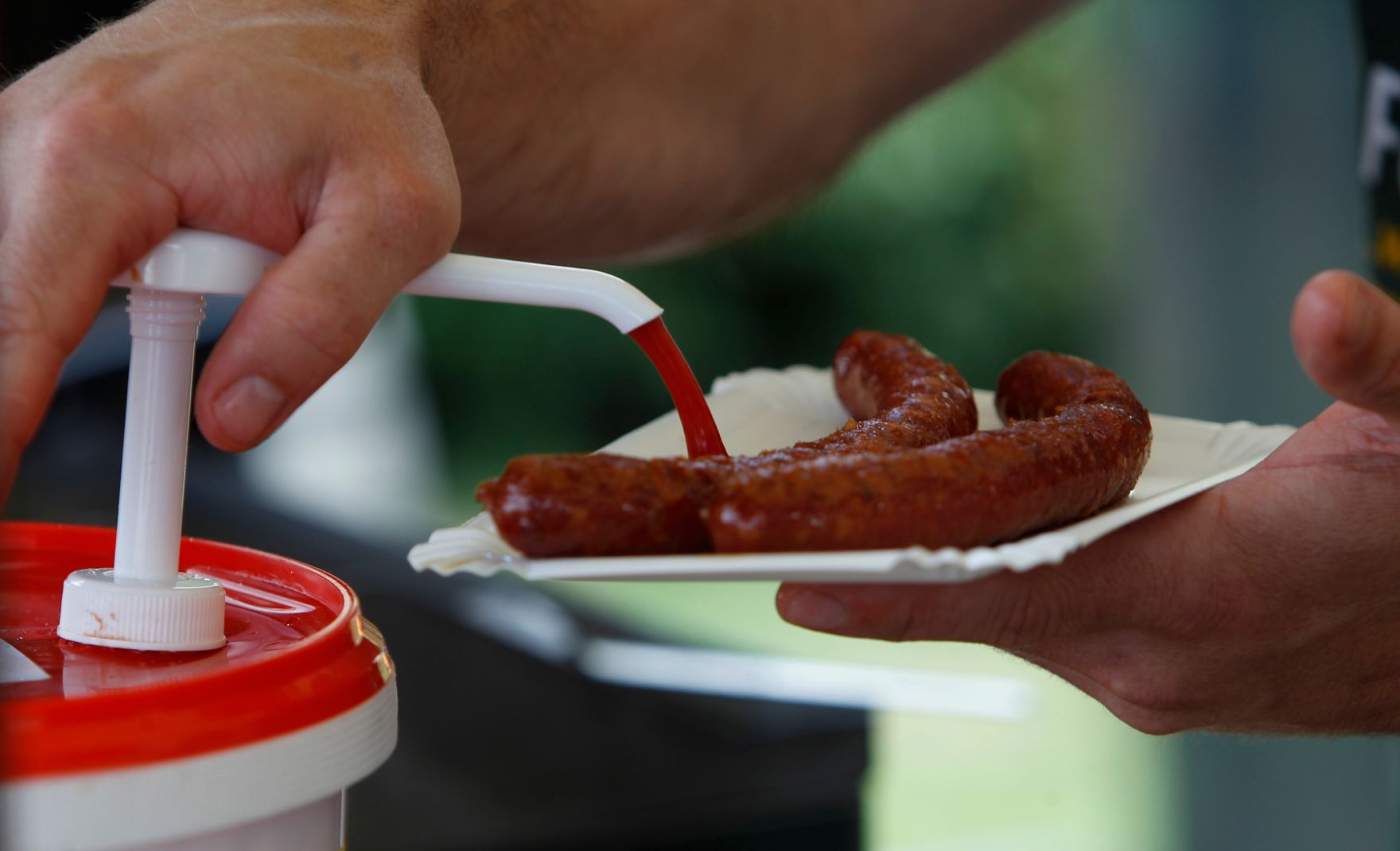 Eine Portion Ketchup zu den W&uuml;rstel. Schlagworte: Bauernmarkt, Essen, Finger, Gastronomie, Hand, Lebensmittel, Markt, Verkostung, Wirtschaft, Wurst