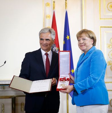 Am 27. August 2015 &uuml;berreichte Bundeskanzler Werner Faymann (l.) das Gro&szlig;e Goldene Ehrenzeichen am Bande f&uuml;r Verdienste um die Republik &Ouml;sterreich an die deutsche Bundeskanzlerin Angela Merkel (r.) im Bundeskanzleramt.