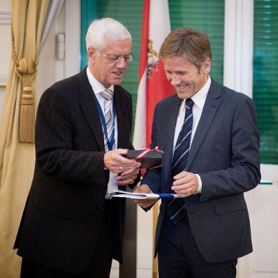 Am 10. September 2012 fand im Bundeskanzleramt ein Empfang zum Internationalen Kongress der Verfassungsgerichtsh&ouml;fe statt. Der Pr&auml;sident des Verfassungsgerichtshofes Gerhart Holzinger (l.) &uuml;berreicht die Pr&auml;sidenten-Runde gepr&auml;gte Medaille an Staatssekret&auml;r Josef Ostermayer (r.).
