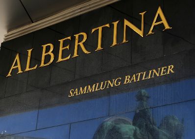 Schild &quot;ALBERTINA SAMMLUNG BATLINER&quot; mit einer Spiegelung der Reiterstaue vor dem Museum. Schlagworte: Beschriftung, Museum, Schild