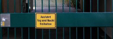 Hinweisschild mit der Aufschrift &quot;Ausfahrt Tag und Nacht freihalten&quot;. Schlagworte: Beschriftung, Schild, Tor, T&uuml;r, Gitter