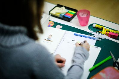 Sch&uuml;ler in einer Schule. Schlagworte: Bunt, Heft, Kind, lernen, Mensch, Stift, Tisch, Unterricht