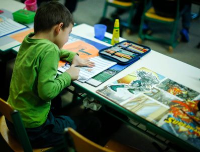 Sch&uuml;ler in einer Schule. Schlagworte: Bunt, Heft, Kind, lernen, Mensch, Stift, Tisch, Unterricht