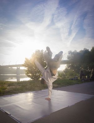 Breakdancer auf der Donauinsel. Schlagworte: Gegenlicht, Handstand, Himmel, Kunst, Mann, Mensch, Musik, Natur, Stadtleben, Wolken