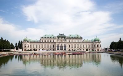 Das Obere Belvedere (S&uuml;dseite) mit bew&ouml;lktem Himmel und Teich im Vordergrund. Schlagworte: Architektur, Blumen, Geb&auml;ude, Himmel, Natur, Park, Schloss, Sehensw&uuml;rdigkeit, Stadtlandschaft, Teich, Wasser, Wolken