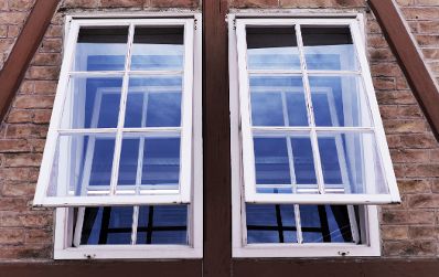 Eine Ziegelsteinfassade mit zwei gekippten Fenstern. Schlagworte: Geb&auml;ude, Stadtlandschaft