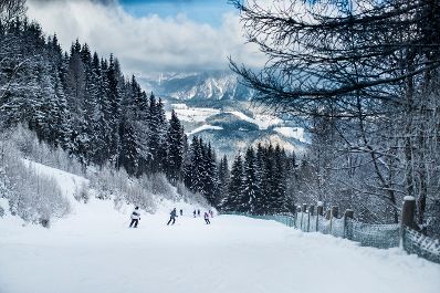 Eine Winterlandschaft in den Bergen. Schlagw&ouml;rter: Natur, Berg, Winter, Schnee, Skifahrer, Schifahrer, Snowboardfahrer, Wolken, Berge, B&auml;ume, Wald, Baum, Rat f&uuml;r Bildung, Jugend, Kultur, Sport, EYC, Rat f&uuml;r Umwelt, ENVI