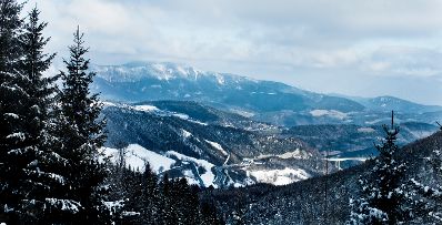 Eine Winterlandschaft in den Bergen. Schlagw&ouml;rter: Natur, Berg, Winter, Schnee, Skifahrer, Schifahrer, Snowboardfahrer, Wolken, Berge, B&auml;ume, Wald, Baum, Rat f&uuml;r Bildung, Jugend, Kultur, Sport, EYC, Rat f&uuml;r Umwelt, ENVI