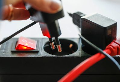 Eine Stromsteckerleiste mit Schalter. Schlagwote: Ger&auml;testecker, Hand, Kabel, Stromverteiler, Technik, Tischsteckdose