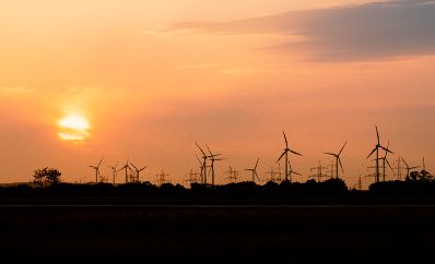 Windkraftanlagen neben Hochspannungsleitungen in Betrieb. Schlagw&ouml;rter: Windkraftanlagen Wind, Energie, Technik, Sonnenuntergang, Strom, Nachhaltigkeit, Hochspannungsleitungen, Starkstrom, Rat f&uuml;r Verkehr, Telekommunikation und Energie, TTE