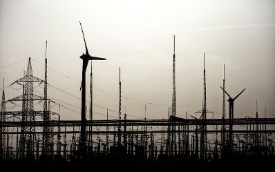 Windkraftanlagen in Betrieb, umgeben von Hochspannungsleitungen und einem Umspannwerk. Schlagw&ouml;rter: Windkraftanlagen, Wind, Energie, Technik, Strom, Nachhaltigkeit, Hochspannung, Rat f&uuml;r Verkehr, Telekommunikation und Energie, TTE