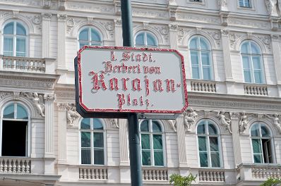 Stra&szlig;enschild &quot;I. Stadt Herbert von Karajan-Platz&quot; vor der Wiener Staatsoper. Schlagworte: Beschriftung, Stra&szlig;enschild, Verkehr