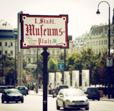 Stra&szlig;enschild &quot;I. Stadt Museums-Platz&quot; Schlagworte: Autos, Beschriftung, Fahrzeuge, PKW, Stadtlandschaften, Stra&szlig;enschild, Verkehr