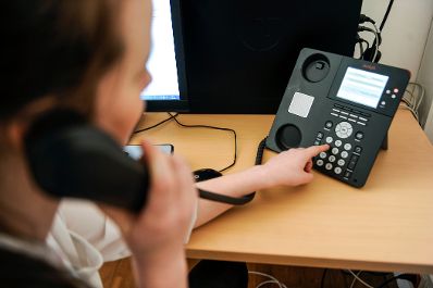 Eine Frau bei der Arbeit. Schlagworte: Arbeitsplatz, Ger&auml;t, Technik, Telefon, Wirtschaft