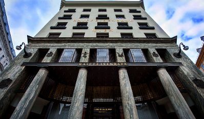 Eine Raiffeisenbank am Michaelaplatz. Schlagworte: Fenster, Geb&auml;ude, S&auml;ulen, Stadtlandschaft, Wirtschaft, Wolken