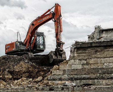 Ein Bagger auf der Baustelle des &Ouml;BB Hauptbahnhofes in Wien. Schlagworte: Abbruch, Bagger, Baustelle, Fahrzeug, Mauer, Wirtschaft, Wolken