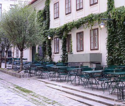 Ein Gastgarten am Spittelberg. Schlagworte: B&auml;ume, Fenster, Gastronomie, Geb&auml;ude, Laternen, Lokal, Stadtlandschaft, Sessel, St&uuml;hle, Tische, Wirtschaft