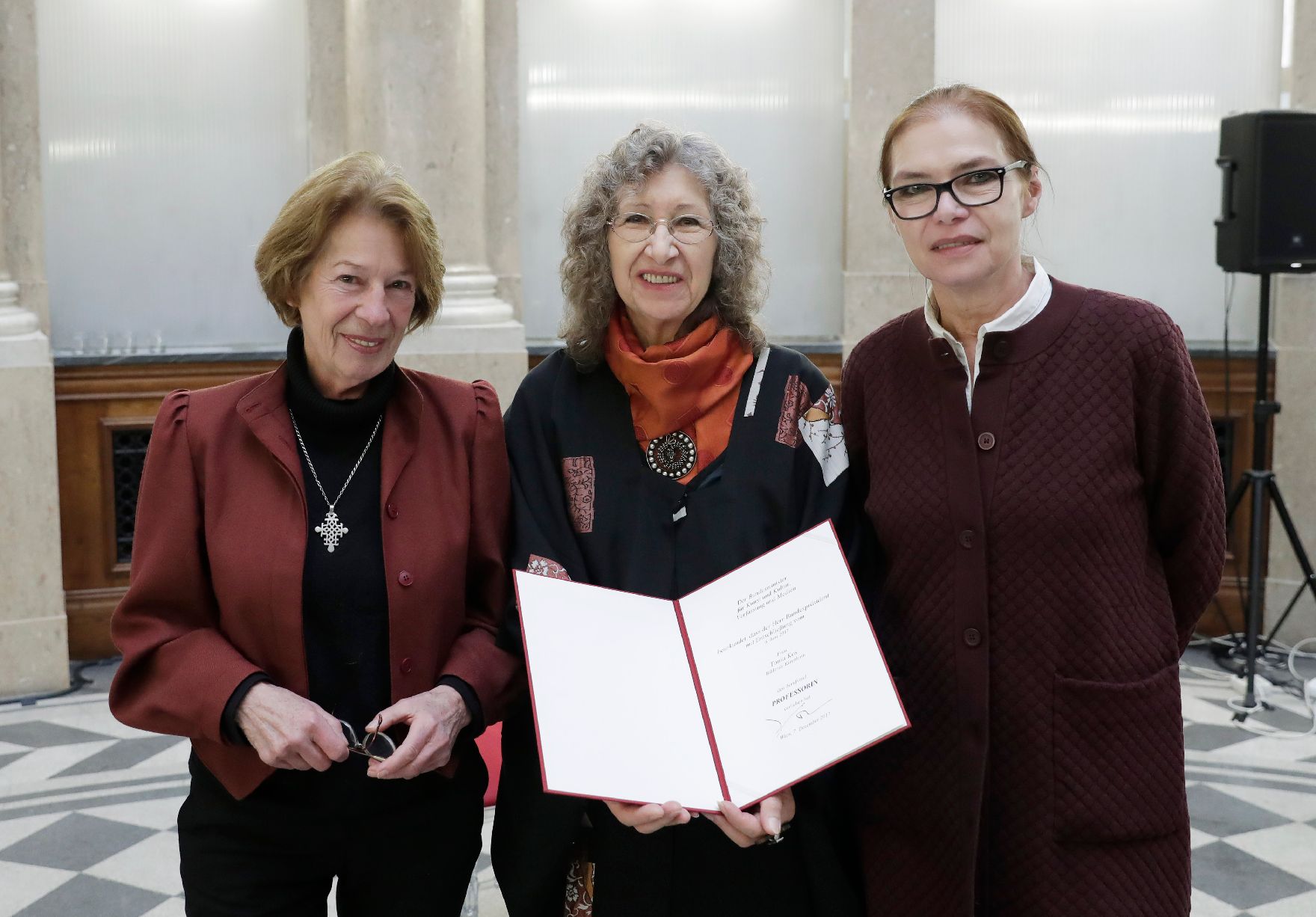 Am 7. Dezember 2017 überreichte Charlotte Sucher (r.) die Urkunde, mit der Tonia Kos (m.) der Berufstitel Professorin verliehen wurde. Im Bild mit Laudatorin Heide Breuer (l.).