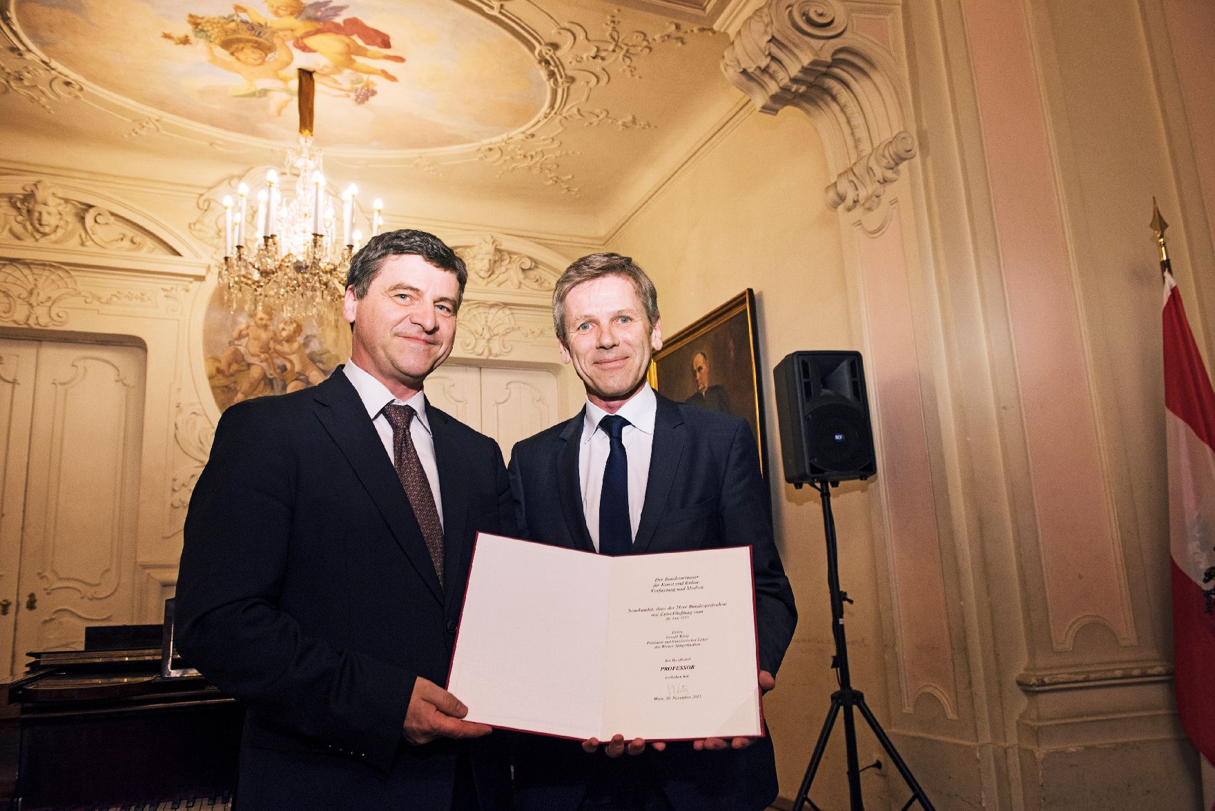 Am 20. November 2015 überreichte Kunst- und Kulturminister Josef Ostermayer (r.) die Urkunde mit der dem Präsidenten der Wiener Sängerknaben Gerald Wirth (l.) der Berufstitel Professor verliehen wurde.