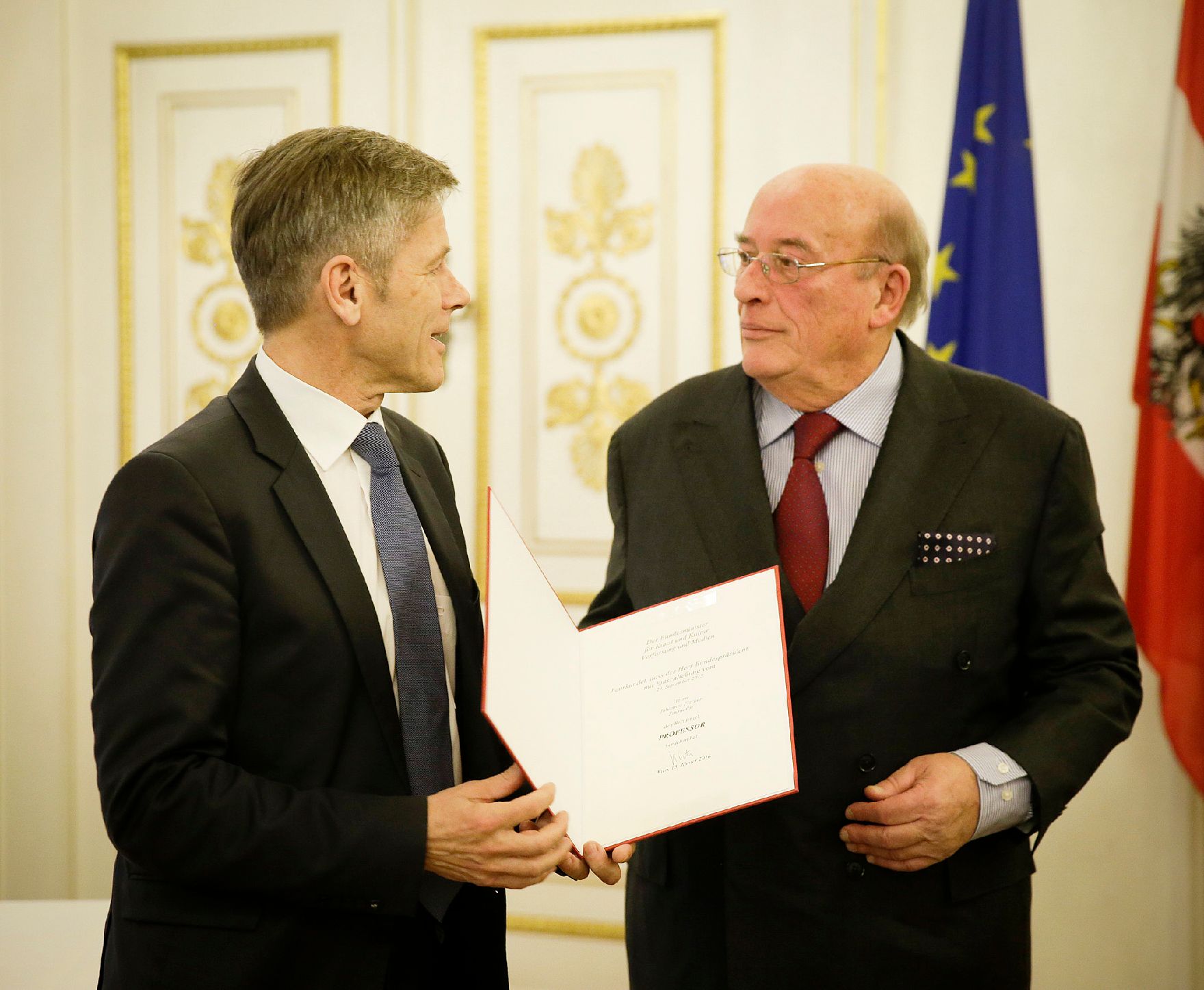 Am 13. Jänner 2016 überreichte Kunst- und Kulturminister Josef Ostermayer (l.) die Urkunde, mit der Johannes Fischer (r.) der Berufstitel Professor verliehen wurde.