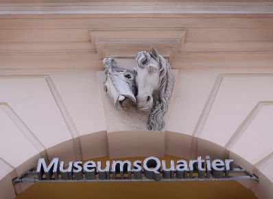 Schriftzug "MuseumsQuartier". Darüber ein Pferdekopf mit Maske. Schlagworte: Beschriftung, Schild
