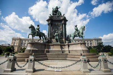 Das Maria-Theresien-Denkmal. Schlagwörter: Denkmal, Sehenswürdigkeit, Stadtlandschaft, Statue, Wolken