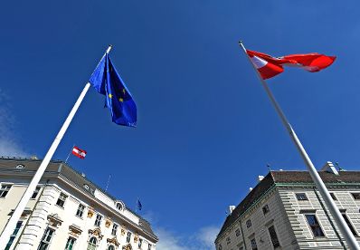 Am Ballhausplatz wehen die europäische und die österreichische Fahne im Wind. Schlagworte: Bundeskanzleramt, Fahnen, Flaggen, Himmel, Masten