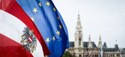 Die österreichische und europäische Fahne wehen im Wind. Im Hintergrund das Rathaus. Schlagworte: Bundesadler, Fahnen, Flaggen