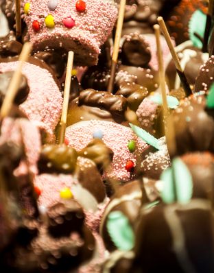 Mit Schokolade überzogene Äpfel am Christkindlmarkt. Schlagworte: Essen, Schokolade, Süßigkeiten, Zuckerstreusel