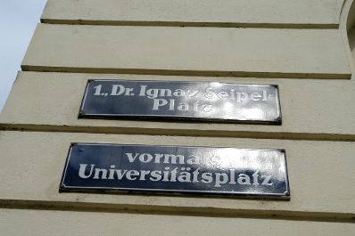 Straßenschilder: "1. Dr. Ignaz Seipel-Platz" "vormals Universitätsplatz". Schlagworte: Beschriftung, Straßenschild, Verkehr